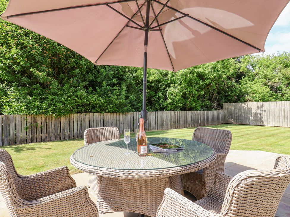 A table with four chairs under an umbrella at The Wagon Shed in Gransmoor near Bridlington