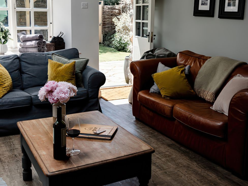 A living room with sofas and a coffee table at Bridge End Cottage in Stainforth