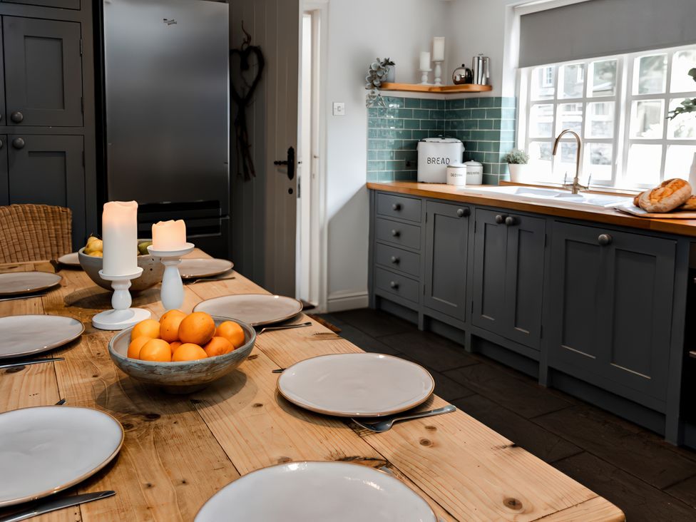 A kitchen with a dining table set for a meal at Bridge End Cottage in Stainforth