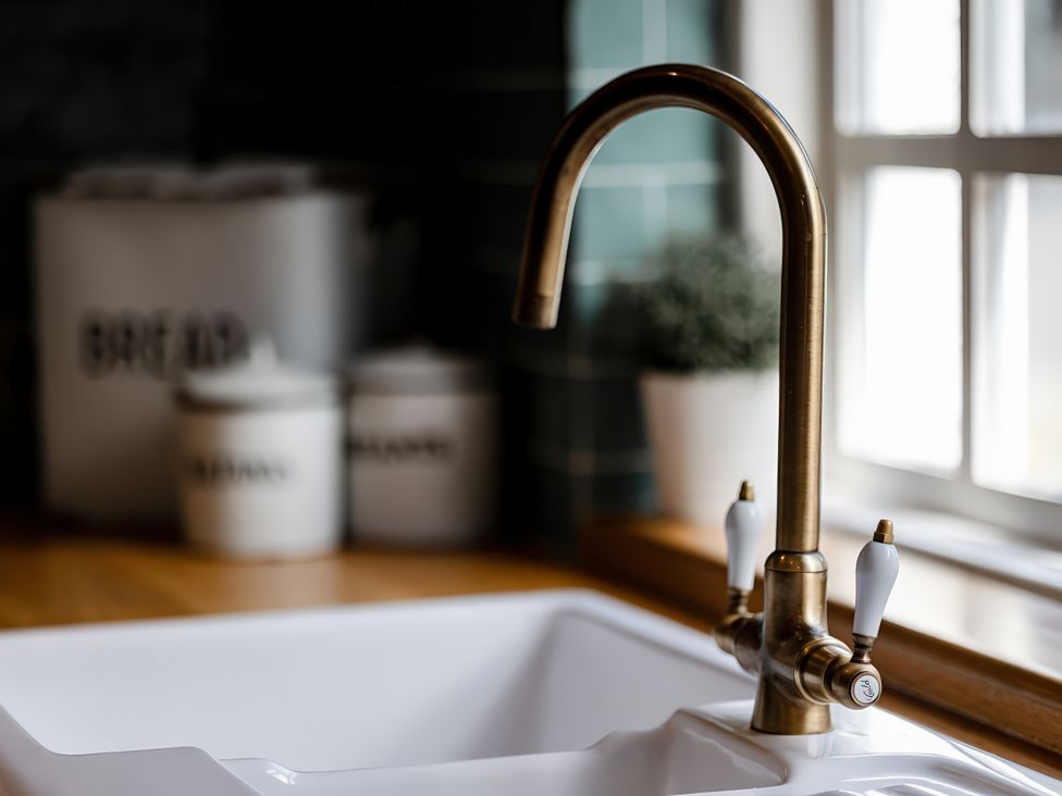 A kitchen with a sink and faucet at Bridge End Cottage Stainforth