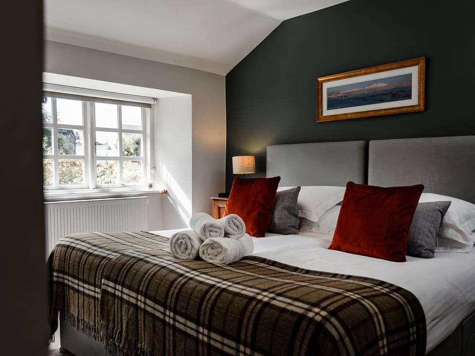 A bedroom with a bed and pillows at Bridge End Cottage Stainforth