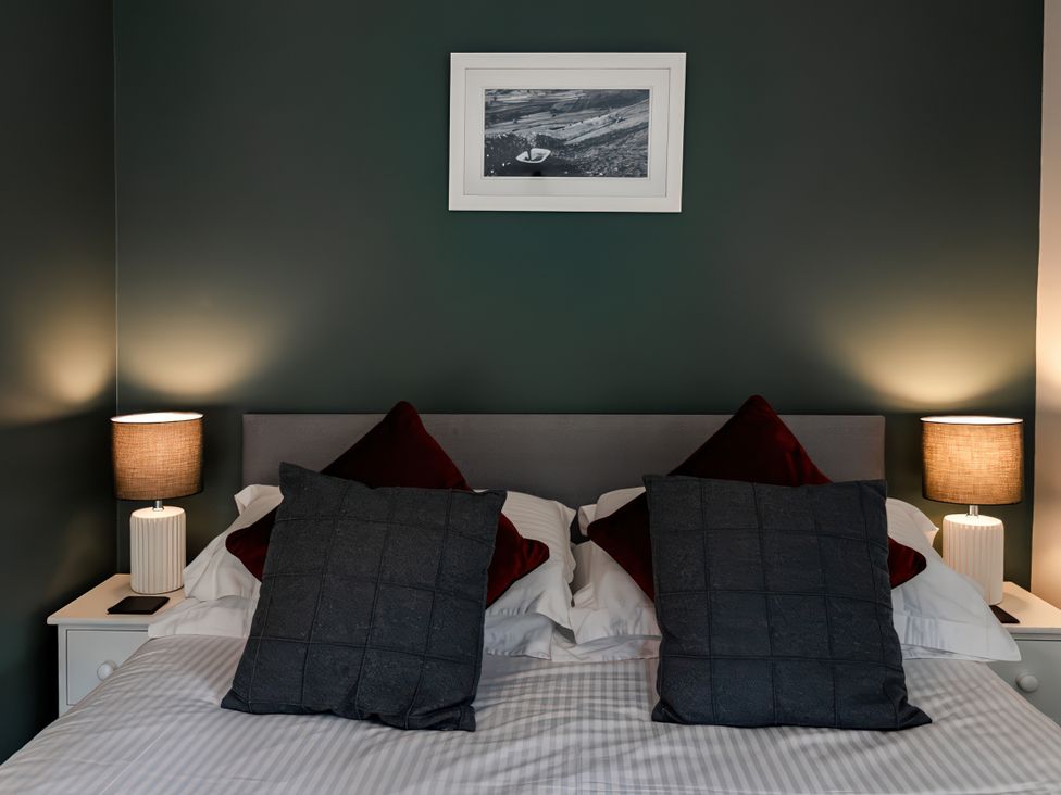 A bedroom with a bed and lamps at Bridge End Cottage in Stainforth