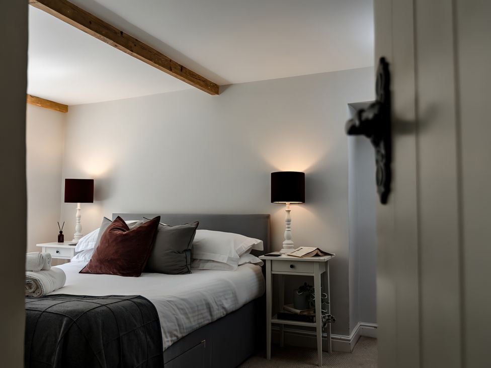 A bedroom with a bed and bedside table at Bridge End Cottage in Stainforth