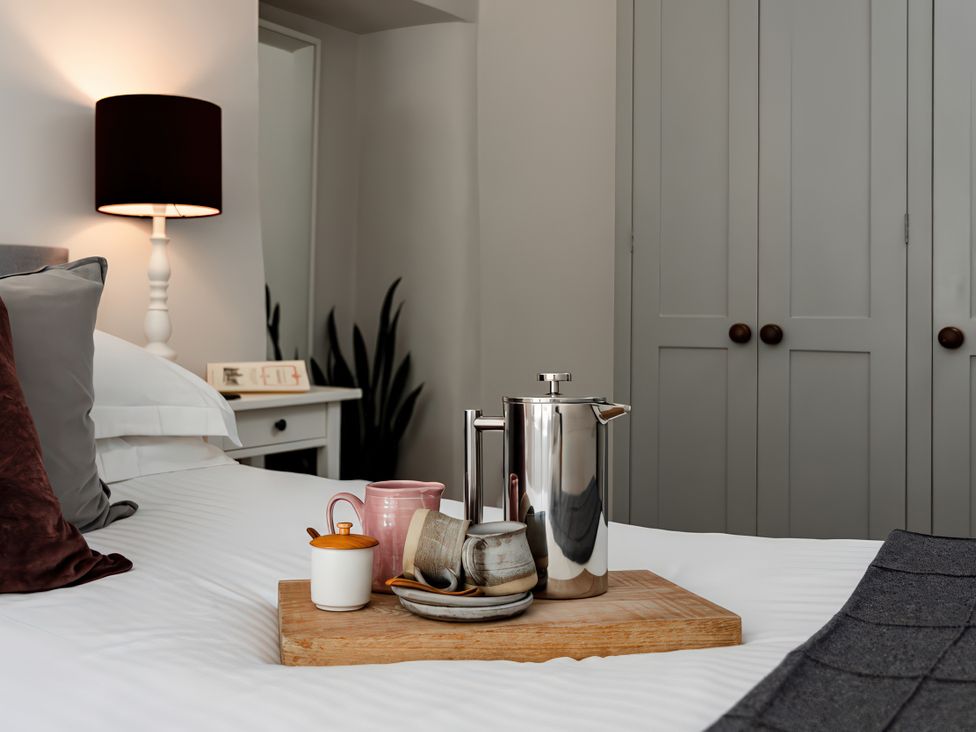 A bedroom with bed, lamp, and coffee tray at Bridge End Cottage in Stainforth