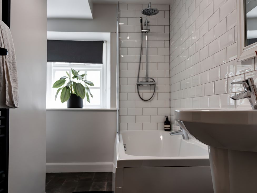 A bathroom with a bathtub and sink at Bridge End Cottage Stainforth