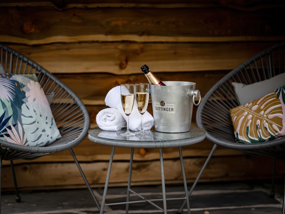 An outdoor seating area with champagne glasses and an ice bucket at Bridge End Cottage in Stainforth