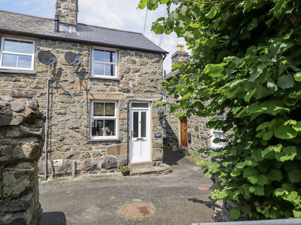 A stone house with a front door and windows at Cae Tanws Bach in Dolgellau