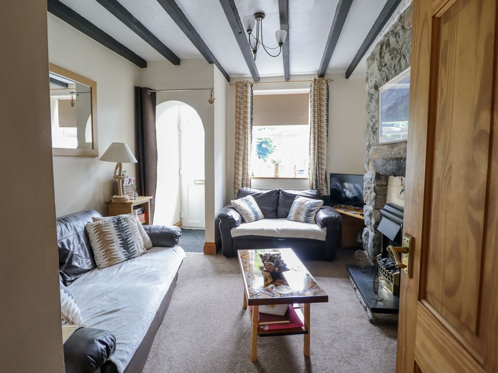 A living room with a sofa and coffee table at Cae Tanws Bach in Dolgellau