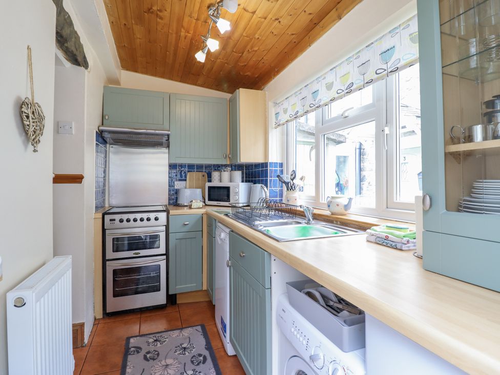 A kitchen with cabinets, sink and oven at Cae Tanws Bach Dolgellau