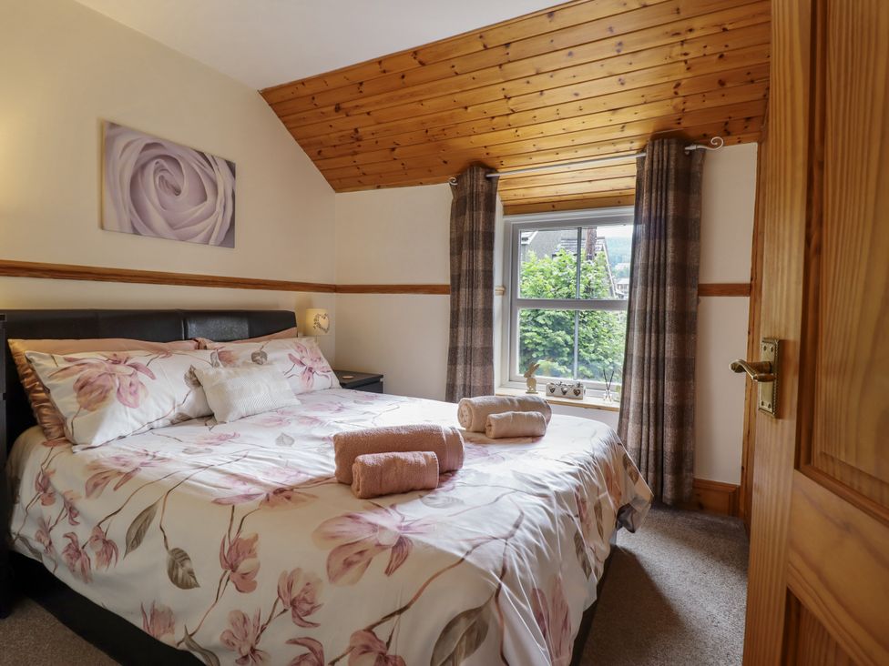 A bedroom with a bed and window at Cae Tanws Bach in Dolgellau