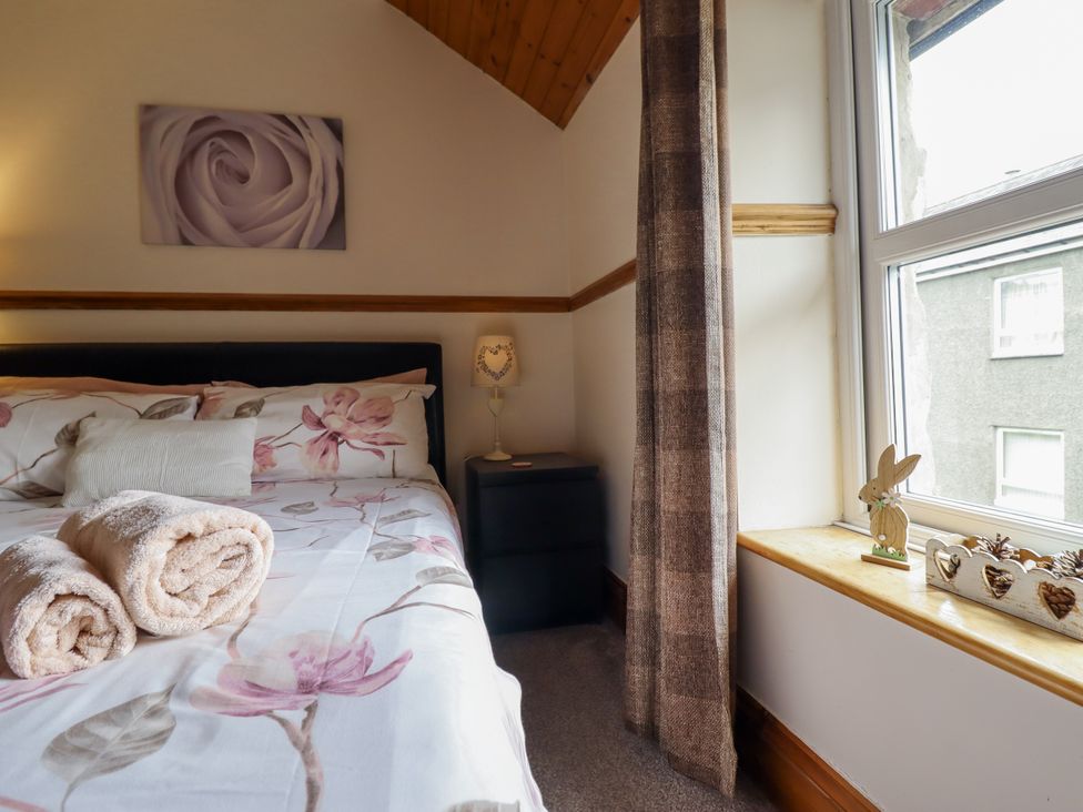 A bedroom with a bed and decorative items at Cae Tanws Bach in Dolgellau