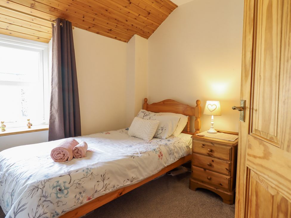 A bedroom with a single bed and a nightstand at Cae Tanws Bach in Dolgellau