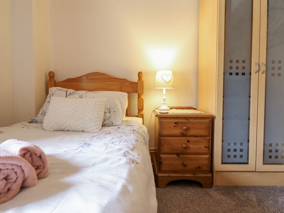 A bedroom with a bed and bedside table at Cae Tanws Bach Dolgellau