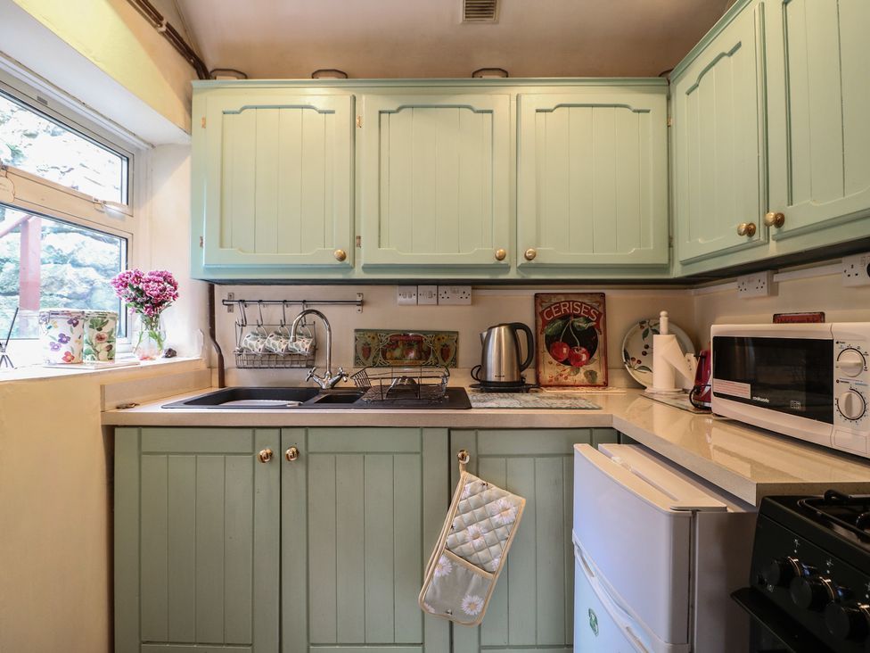 A kitchen featuring cabinets, sink, kettle, and microwave at 40 Water Lane Matlock