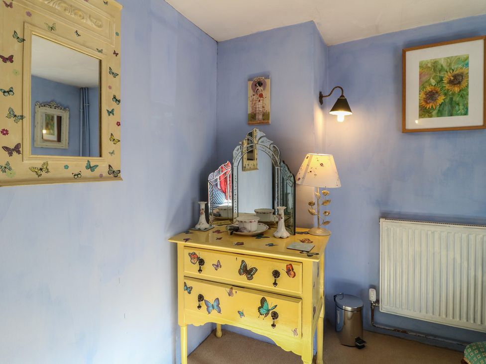A dressing room with a yellow dressing table and mirror at 40 Water Lane Matlock