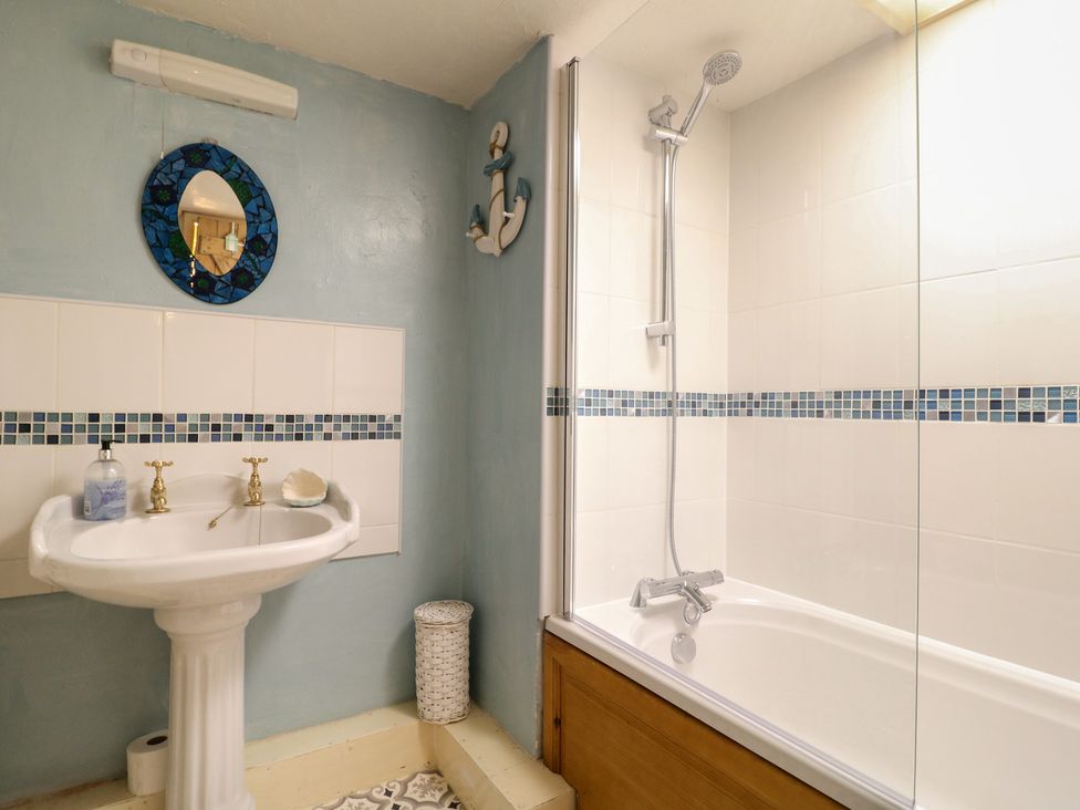 A bathroom featuring a sink, mirror, shower, and bathtub at 40 Water Lane Matlock