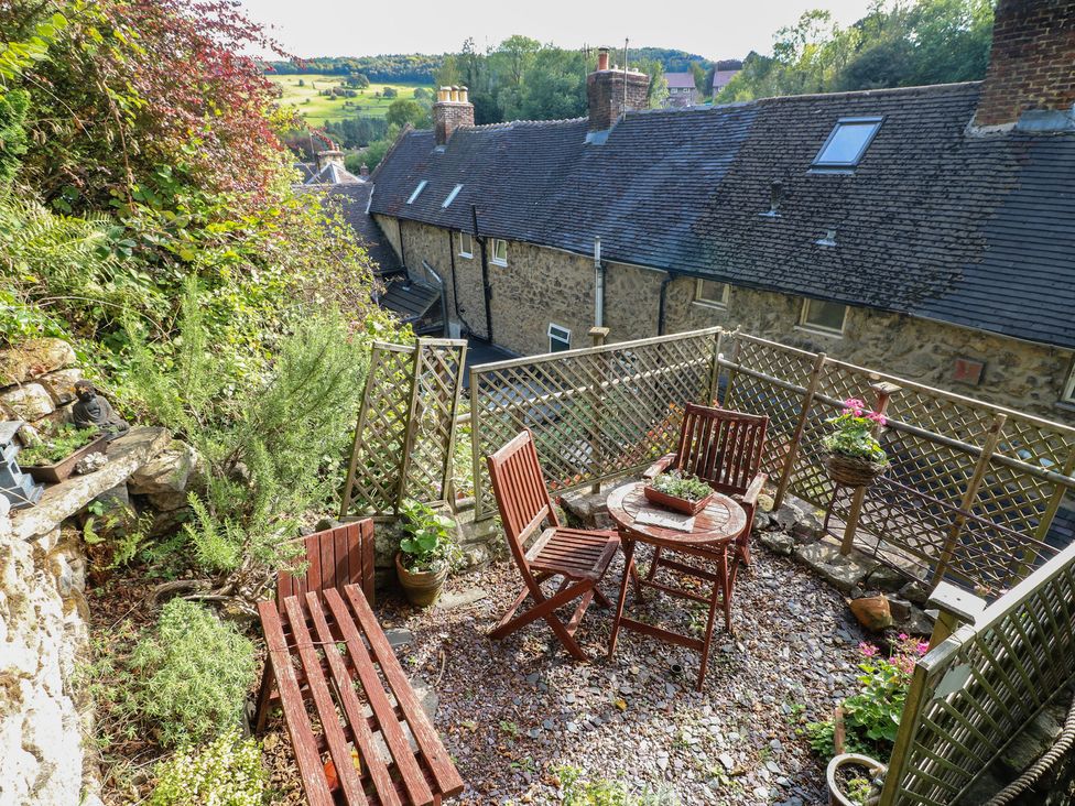 A garden with wooden furniture and plants at 40 Water Lane Matlock