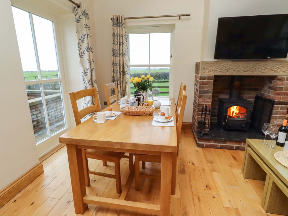 A dining room with a table and chairs at Bank Top Cottage in Embleton