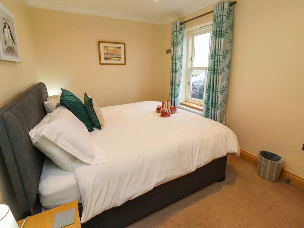 A bedroom with a bed and window at Bank Top Cottage in Embleton