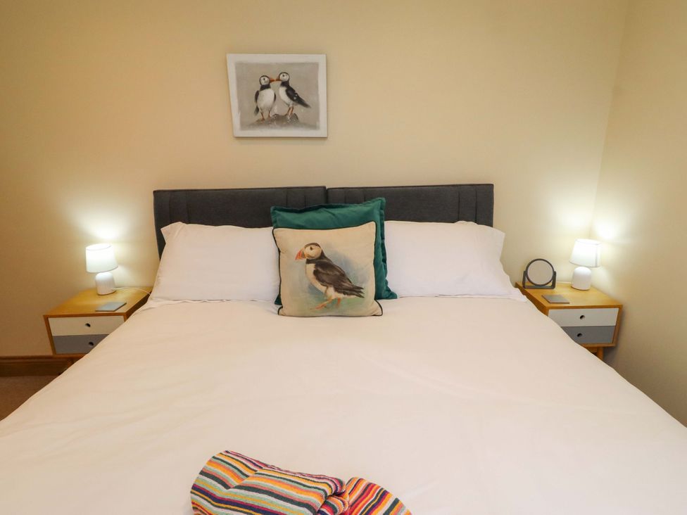 A bedroom with a bed and wall art at Bank Top Cottage in Embleton
