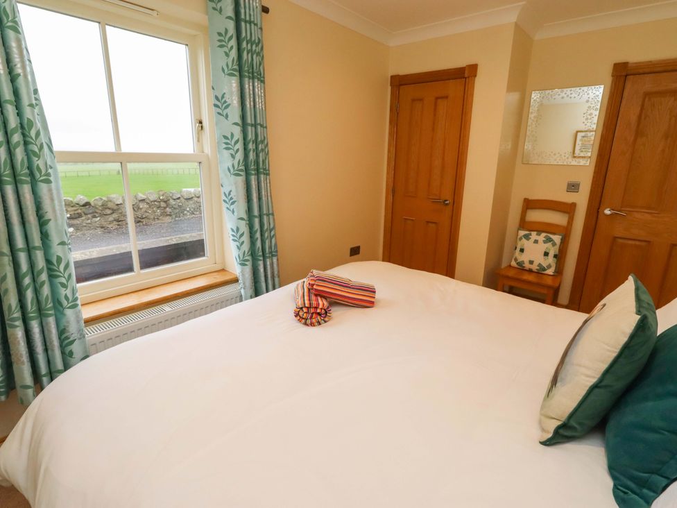 A bedroom with a bed and window at Bank Top Cottage in Embleton