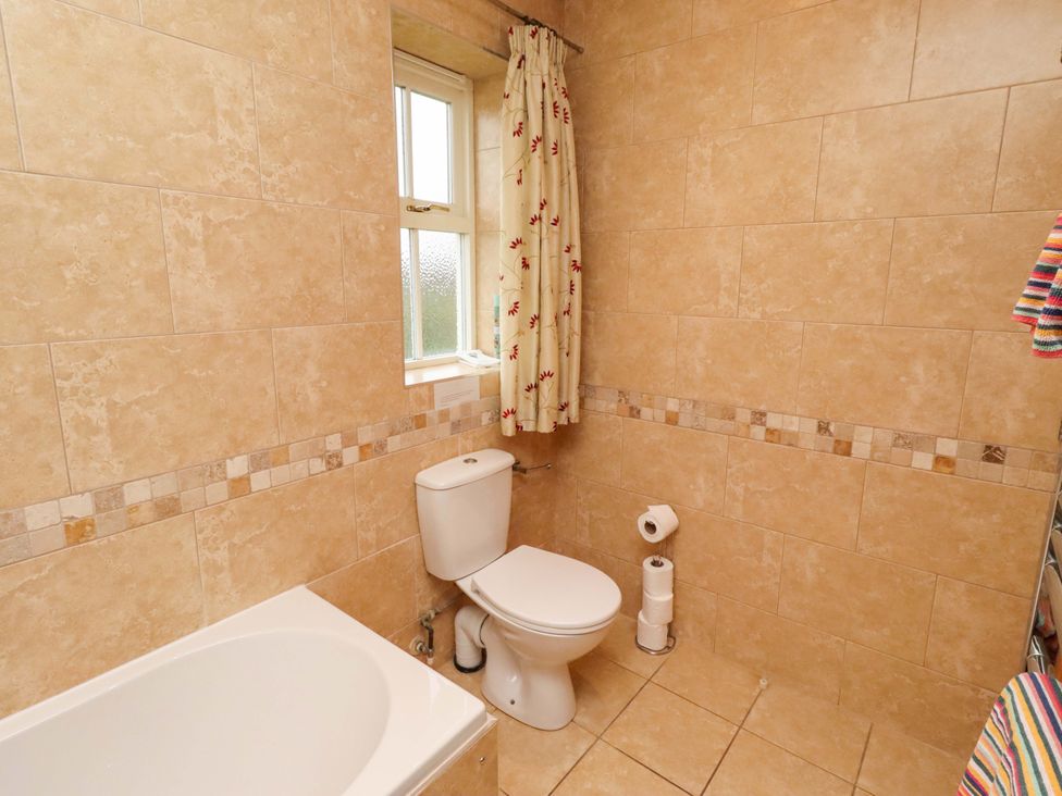 A bathroom with a bathtub and toilet at Bank Top Cottage in Embleton