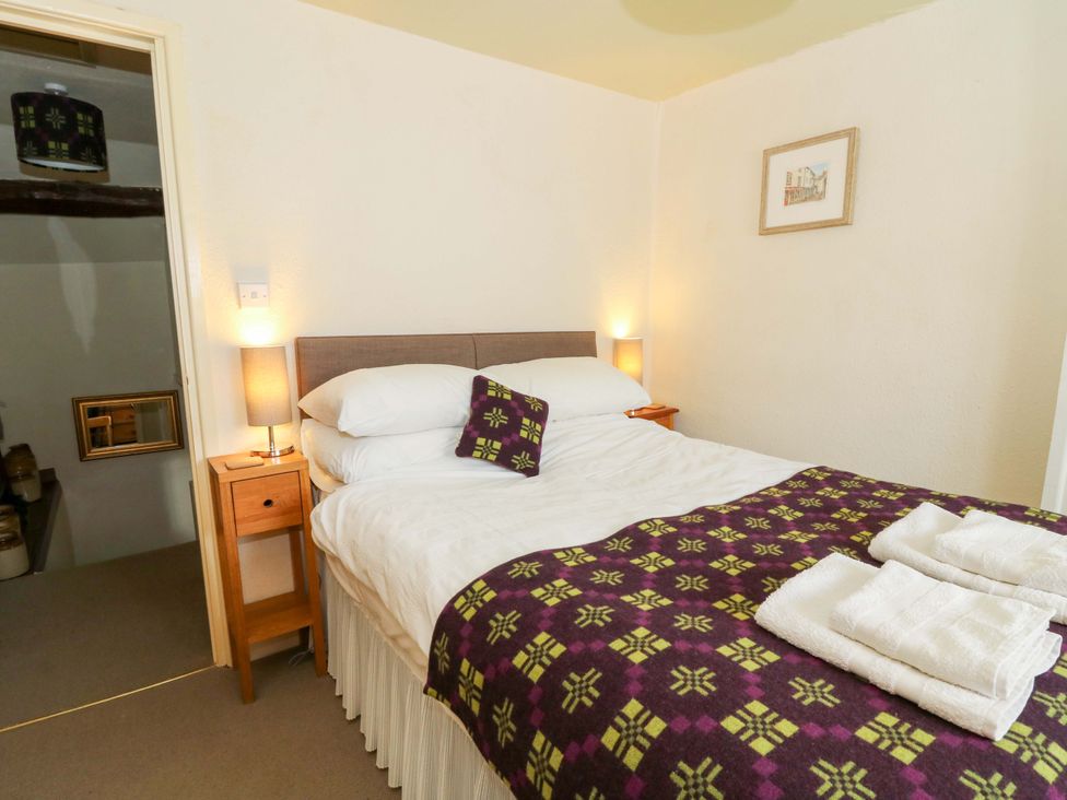 A bedroom with a bed and bedside table at Chancery Cottage in Hay-On-Wye