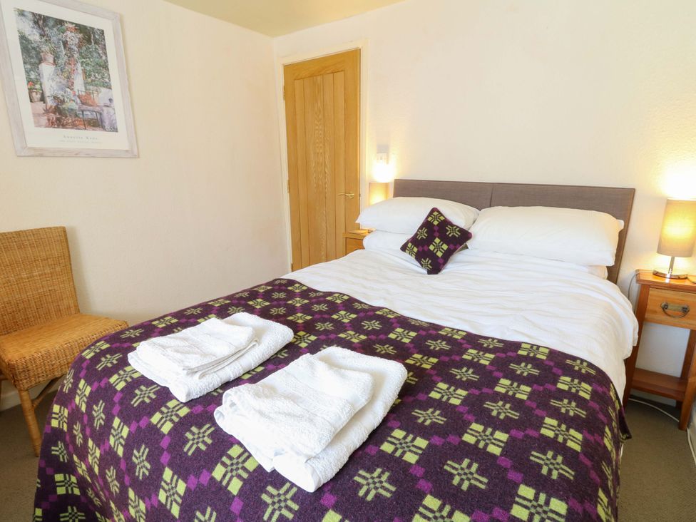 A bedroom with a bed and towels at Chancery Cottage in Hay-On-Wye