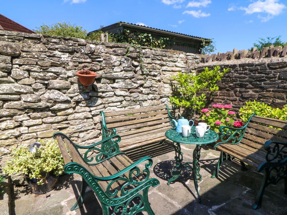 A garden seating area with a stone wall at Chancery Cottage in Hay-On-Wye