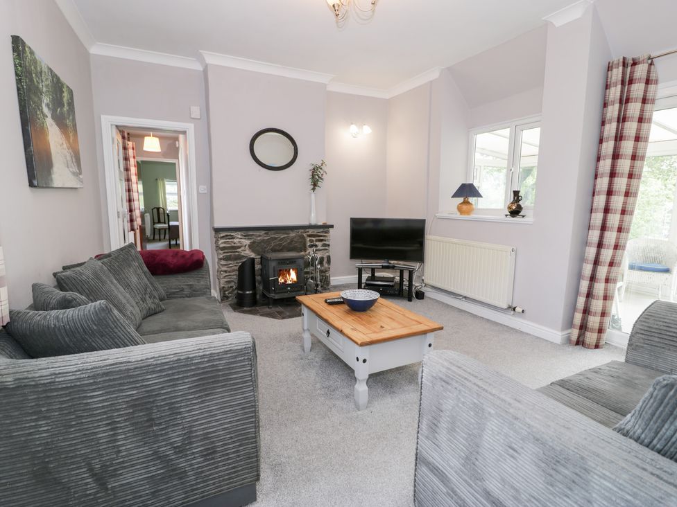 A living room with a fireplace and television at Dyffryn Bach in Glan-yr-afon near Corwen