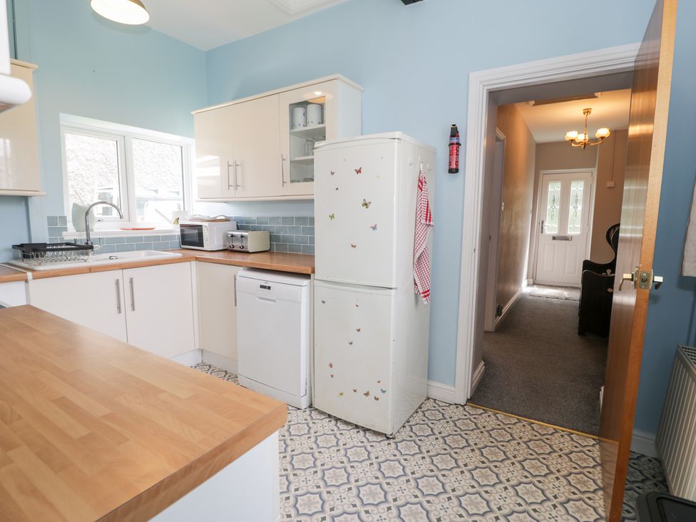 A kitchen with a refrigerator and sink at Dyffryn Bach Glan-yr-afon near Corwen