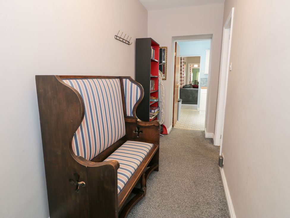 A hallway with a settee and bookcase at Dyffryn Bach in Glan-yr-afon near Corwen