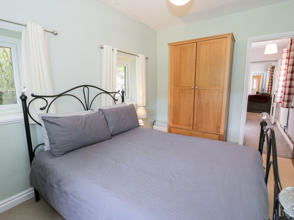 A bedroom with a bed and wardrobe at Dyffryn Bach in Glan-yr-afon near Corwen