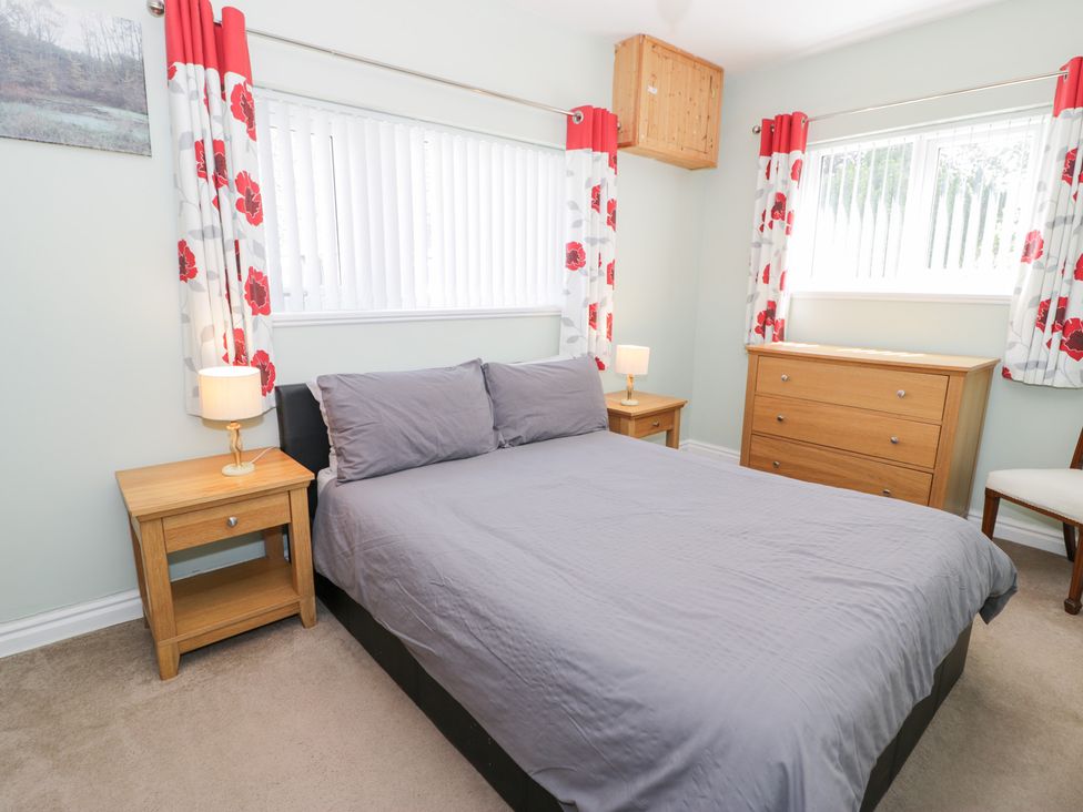 A bedroom with a bed and dresser at Dyffryn Bach in Glan-yr-afon near Corwen