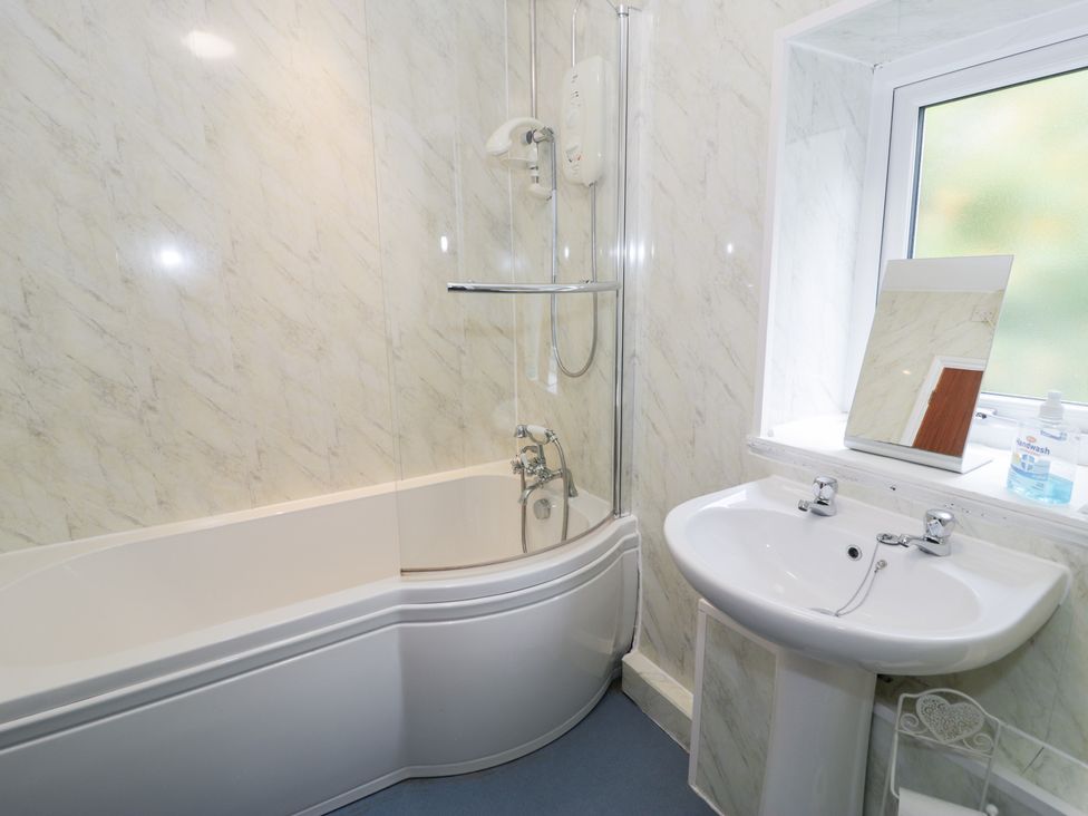 A bathroom with a bathtub and washbasin at Dyffryn Bach near Glan-yr-afon near Corwen