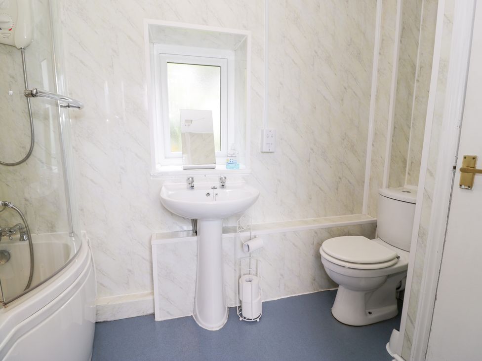 A bathroom with a shower, sink, and toilet at Dyffryn Bach in Glan-yr-afon near Corwen