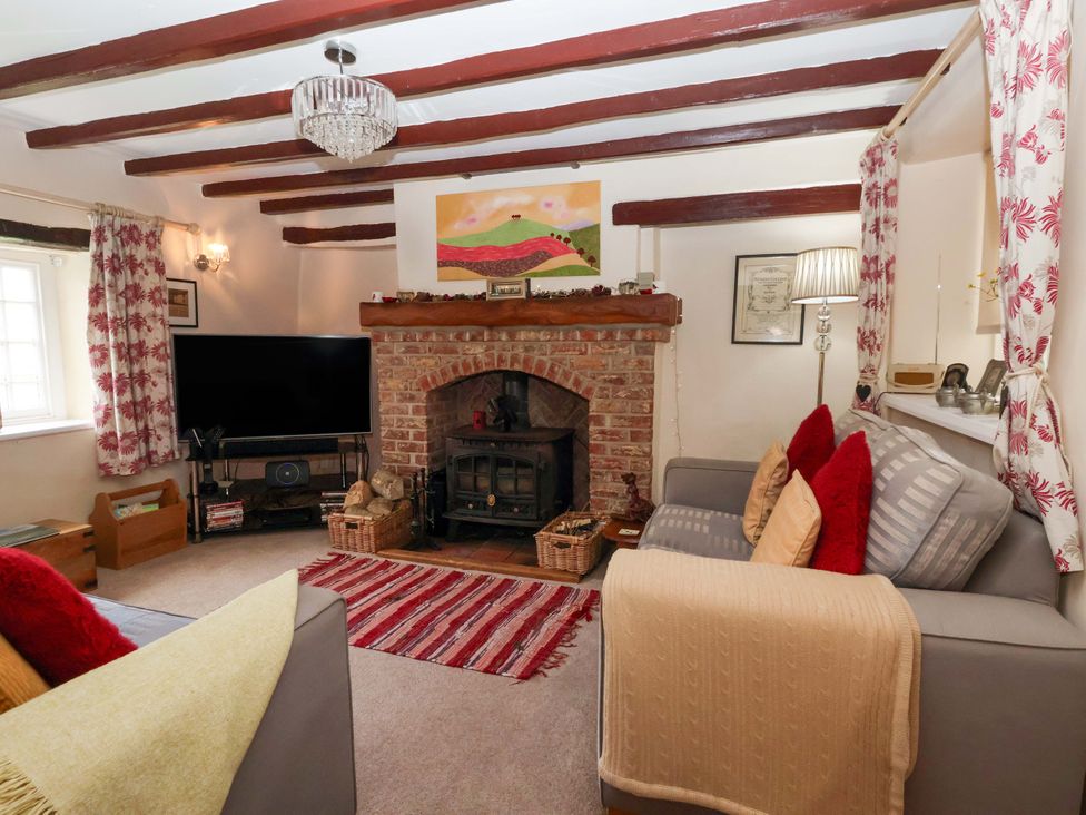 A living room with a fireplace and TV at Clara's Cottage West Lutton near Malton