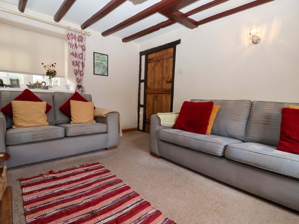 A living room with a sofa and cushions at Clara's Cottage in West Lutton near Malton