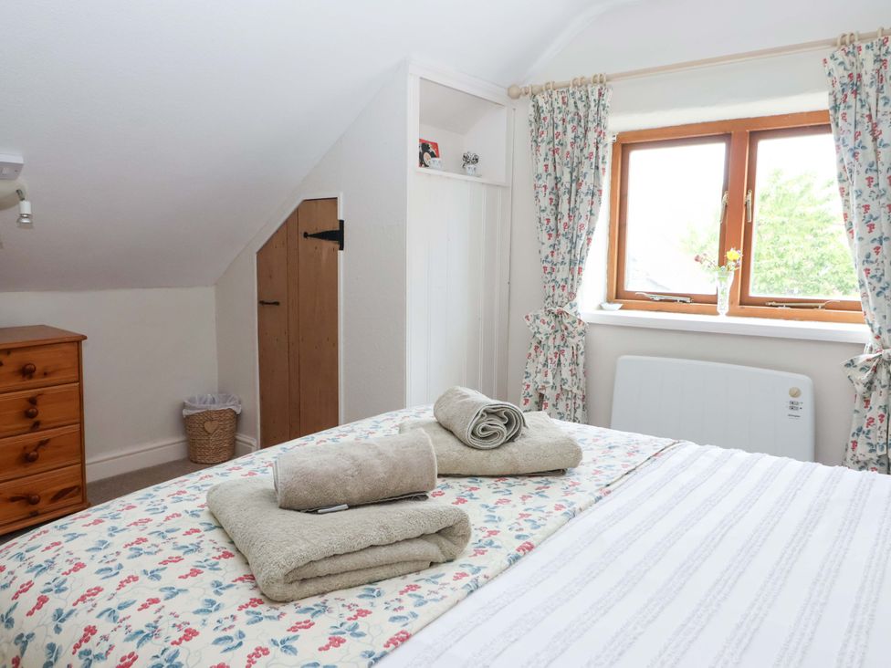 A bedroom with a bed and towels on it at Clara's Cottage in West Lutton near Malton