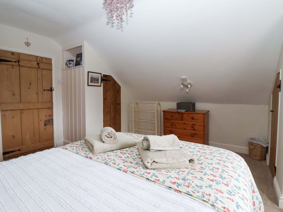 A bedroom with a bed and dresser at Clara's Cottage in West Lutton near Malton