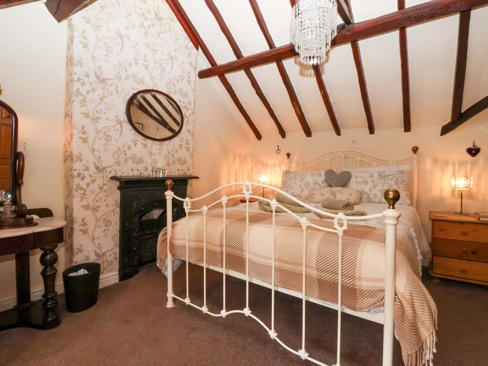 A bedroom with a bed, mirror, and chest of drawers at Clara's Cottage in West Lutton near Malton