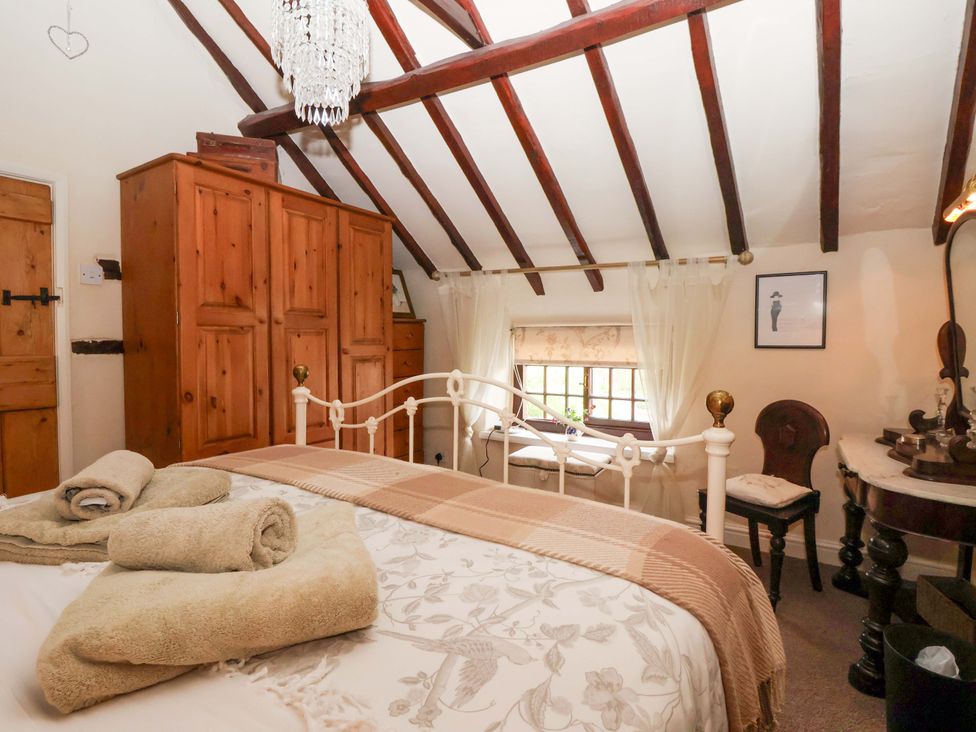 A bedroom with a bed and wardrobe at Clara's Cottage West Lutton near Malton