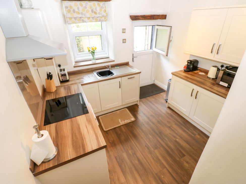 A kitchen with cabinets, stove, and sink at 27 Bongate in Appleby-In-Westmorland
