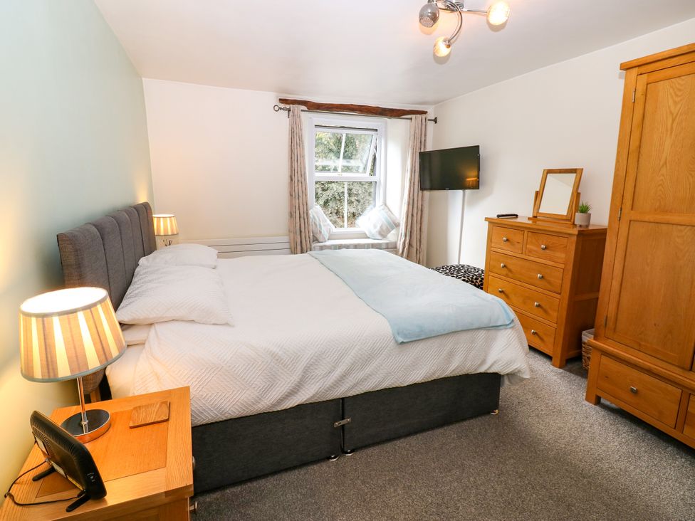 A bedroom with a large bed and furniture at 27 Bongate in Appleby-In-Westmorland