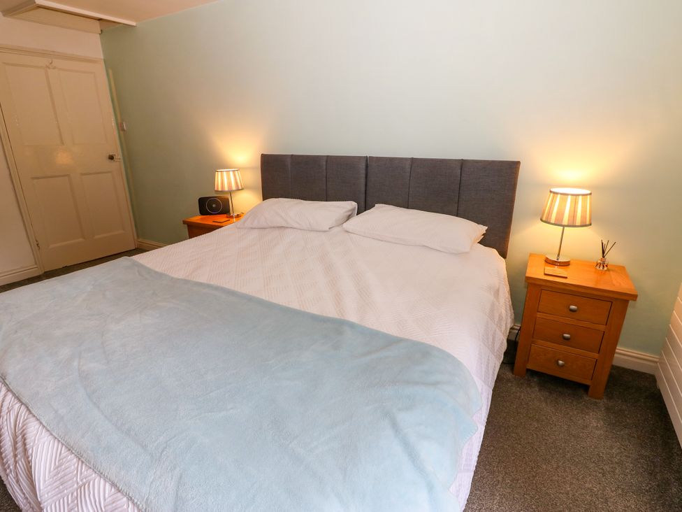 A bedroom with a bed and nightstands with lamps at 27 Bongate in Appleby-In-Westmorland