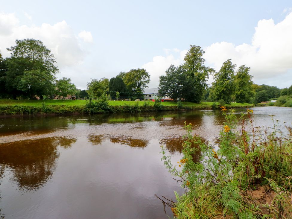 A river with trees and a building in the background at 27 Bongate Appleby-In-Westmorland