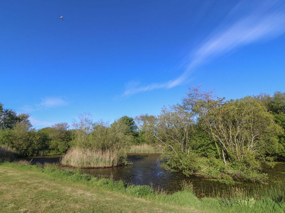 A landscape with water and trees at Ty Woms in Abersoch