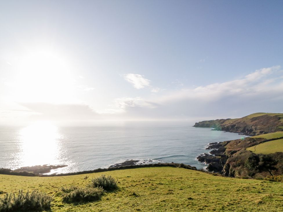 A coastal view with hills and ocean at Tinners Cottage in Liskeard