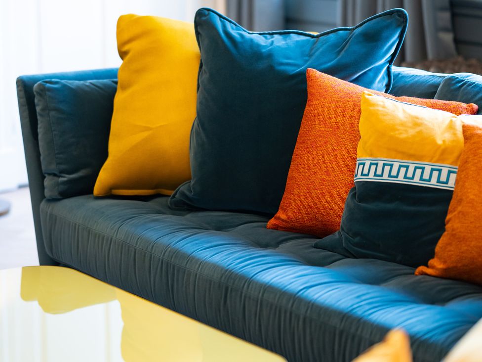 A sofa with cushions in a living room at Wren Place Hall in Worsbrough