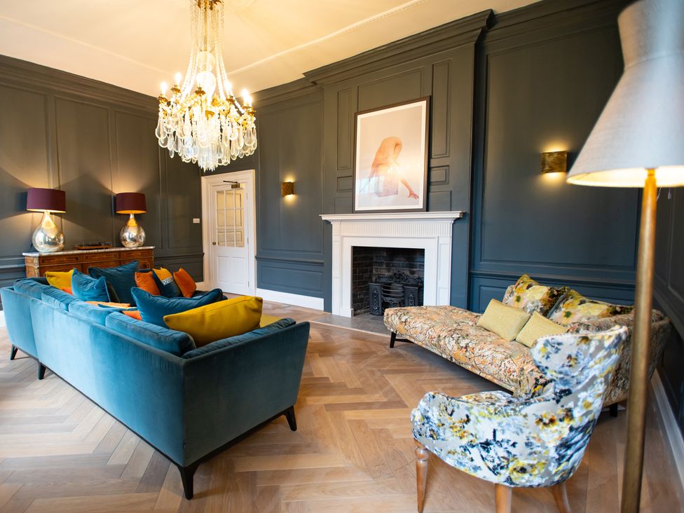 A living room with a sofa and armchair at Wren Place Hall in Worsbrough